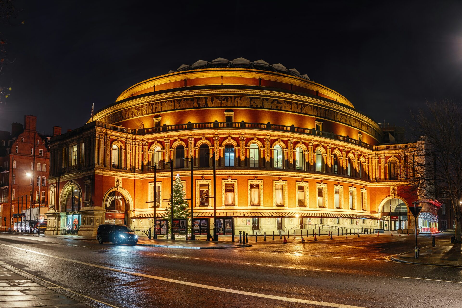 The Royal Albert Hall building is shown at night