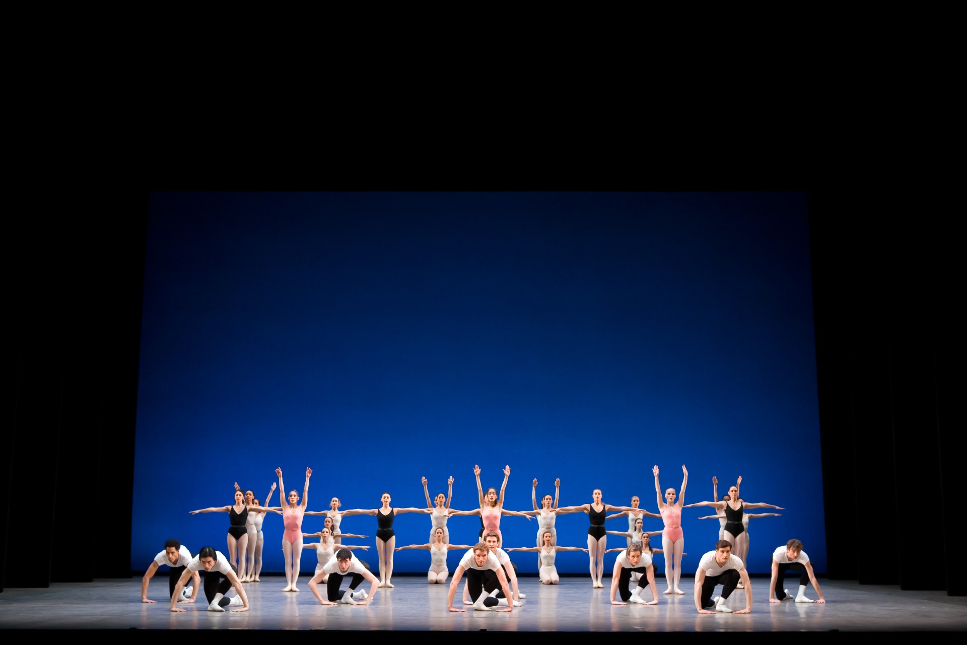 Dancers from Birmingham Royal Ballet on stage with a blue backdrop.